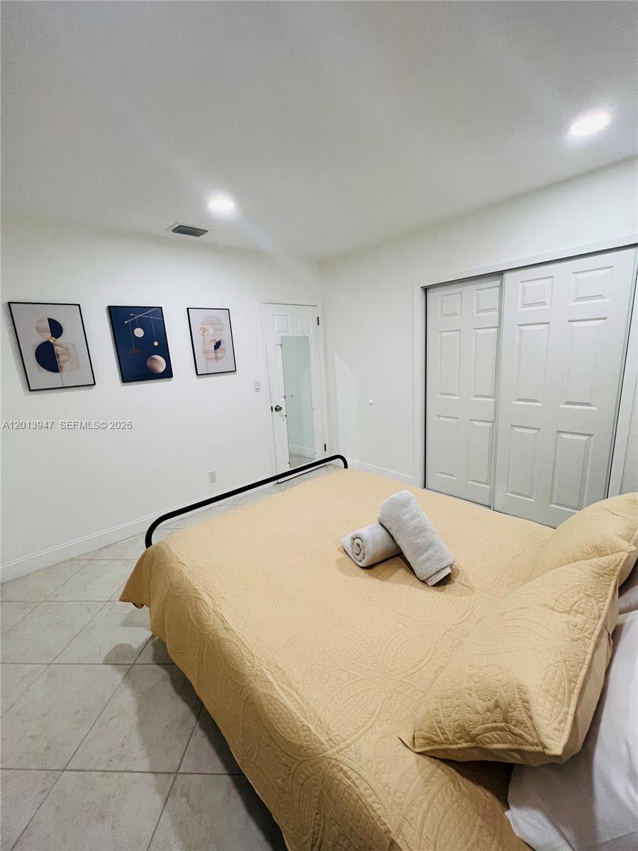 280 Northwest 55th Street, Unit 282 Miami, FL 33127 - Photo 11 of 19 a bedroom with a bed and wall painting