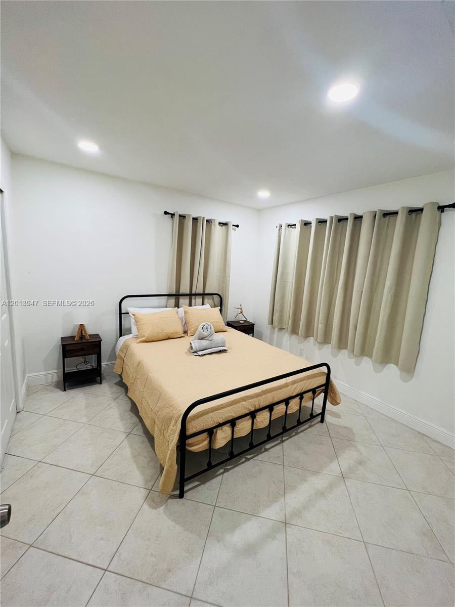 280 Northwest 55th Street, Unit 282 Miami, FL 33127 - Photo 12 of 19 a spacious bedroom with a bed and a table in it