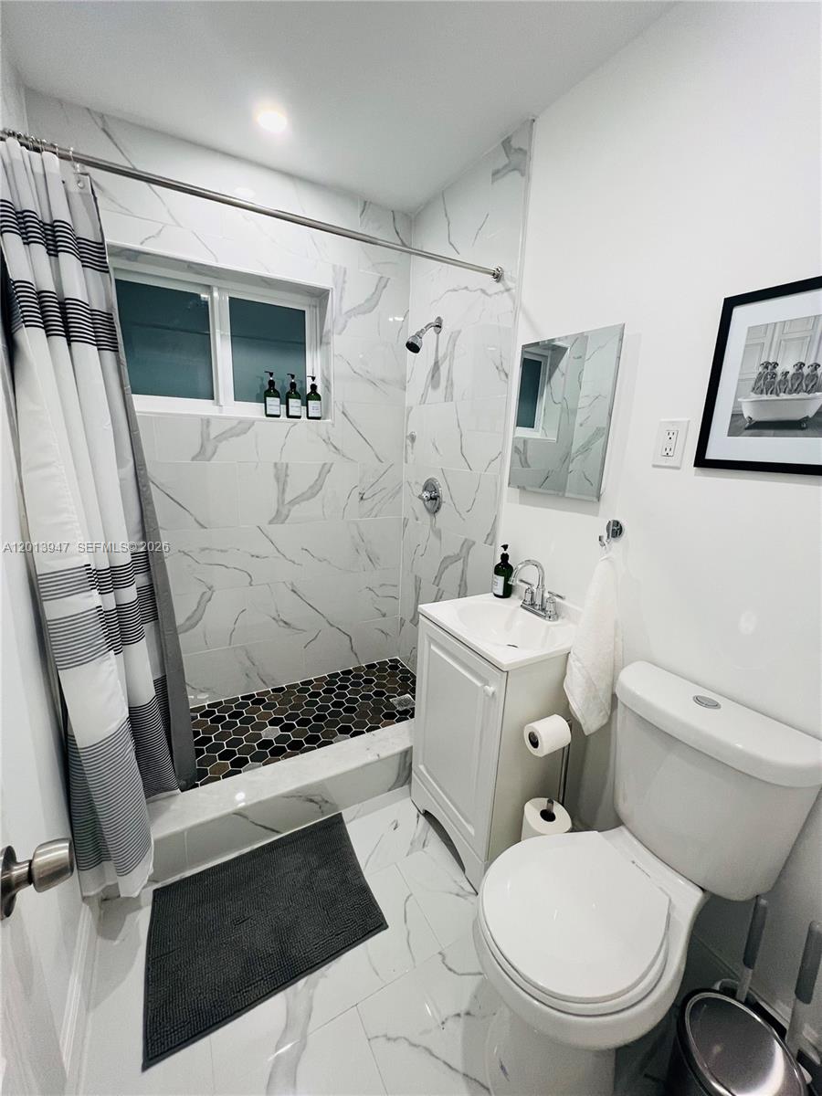 280 Northwest 55th Street, Unit 282 Miami, FL 33127 - Photo 18 of 19 a white toilet sitting next to a bathroom sink