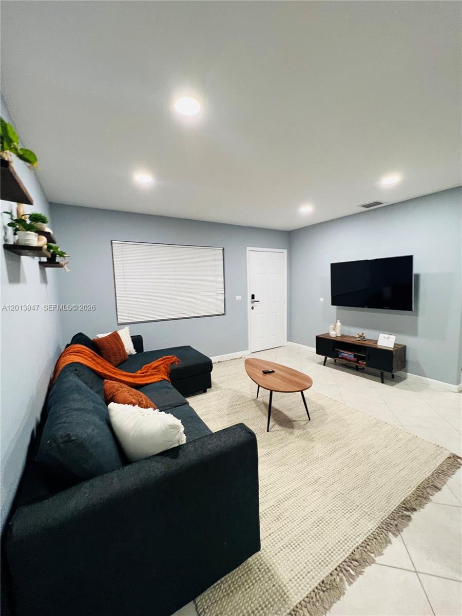 280 Northwest 55th Street, Unit 282 Miami, FL 33127 - Photo 4 of 19 a living room with furniture and a flat screen tv