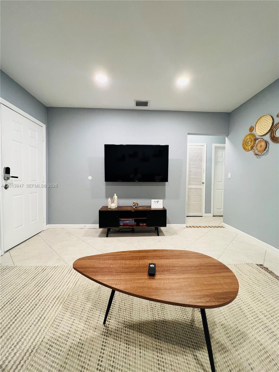 280 Northwest 55th Street, Unit 282 Miami, FL 33127 - Photo 6 of 19 a room with furniture and a flat screen tv