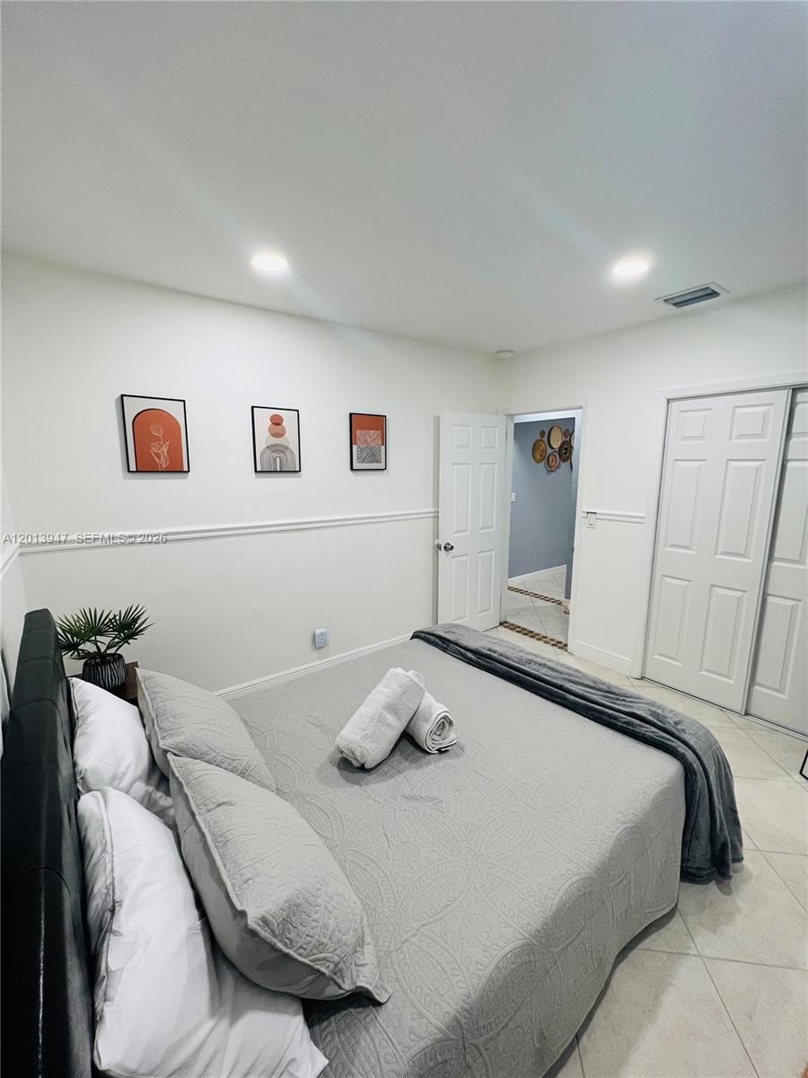 280 Northwest 55th Street, Unit 282 Miami, FL 33127 - Photo 8 of 19 a bedroom with a bed and painting on the wall