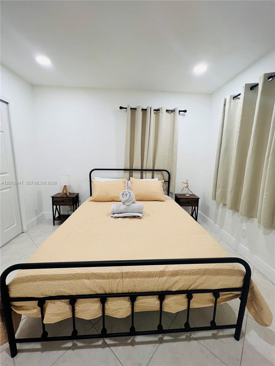 280 Northwest 55th Street, Unit 282 Miami, FL 33127 - Photo 10 of 19 a bedroom with a bed and a table
