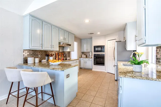 a kitchen with stainless steel appliances granite countertop a refrigerator sink and cabinets