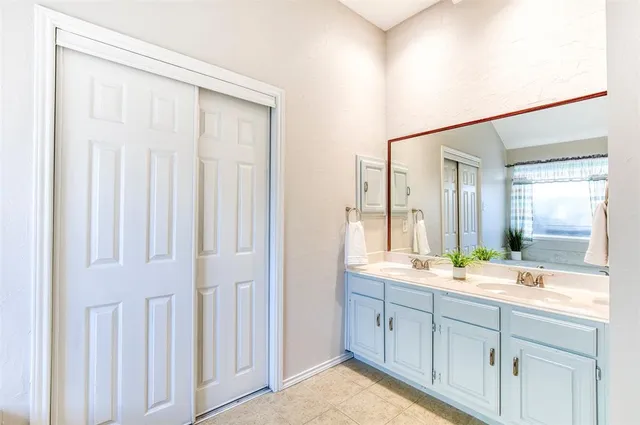 a spacious bathroom with a double vanity sink and a mirror
