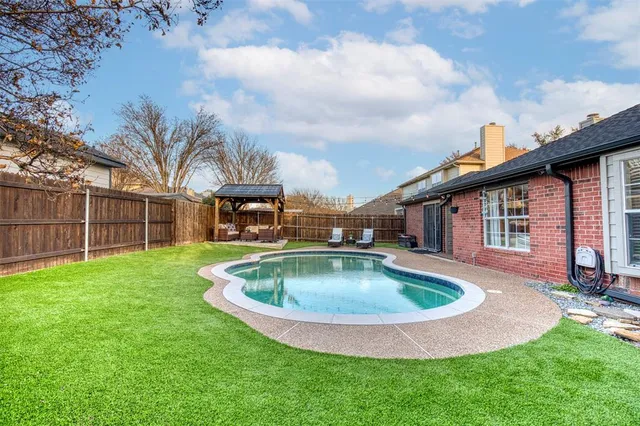a view of a backyard with swimming pool