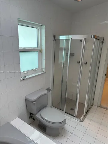 a bathroom with a toilet and a shower