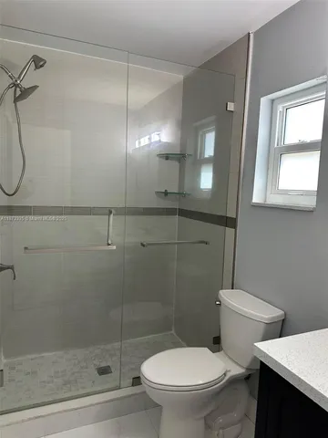 a white toilet sitting next to a bathroom sink