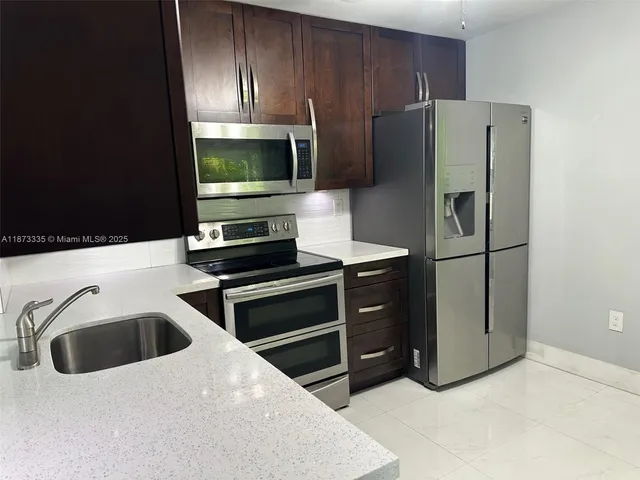 a kitchen with stainless steel appliances a refrigerator stove and sink