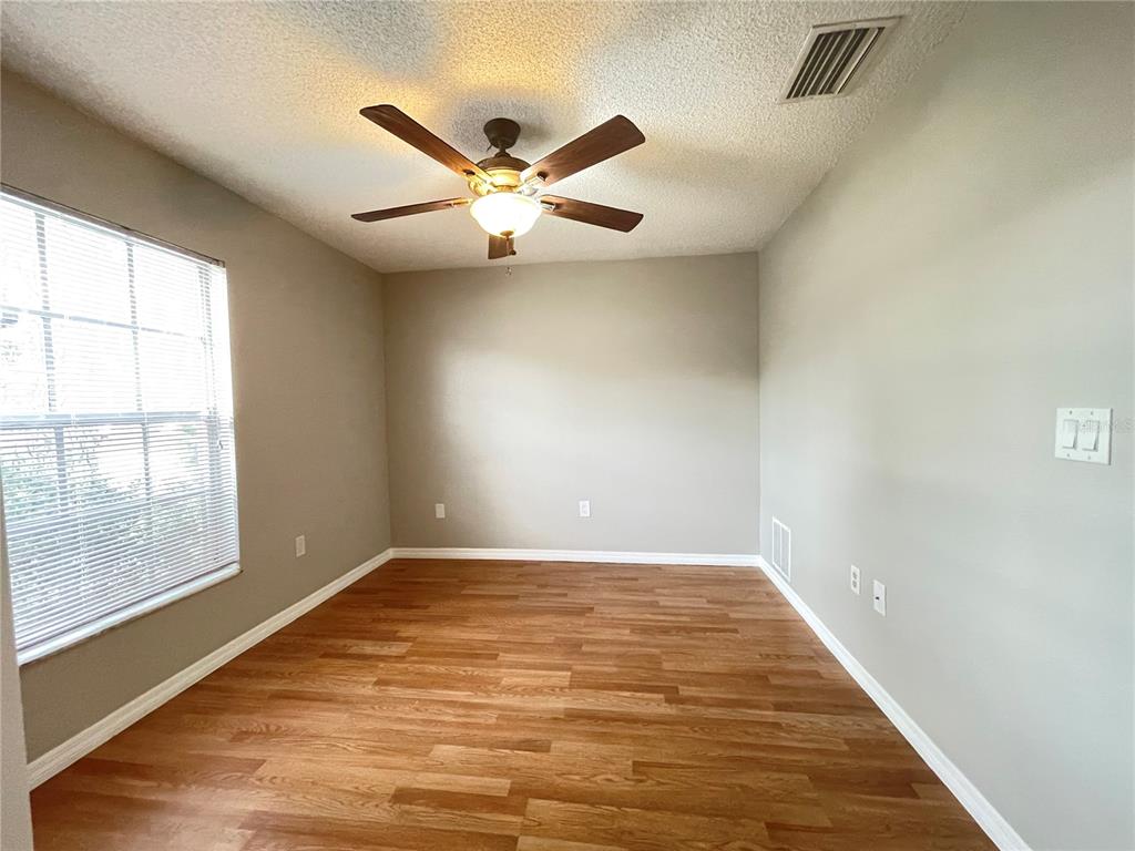7986 Avenal Loop New Port Richey, FL 34655 - Photo 13 of 23 wooden floor in an empty room with a window