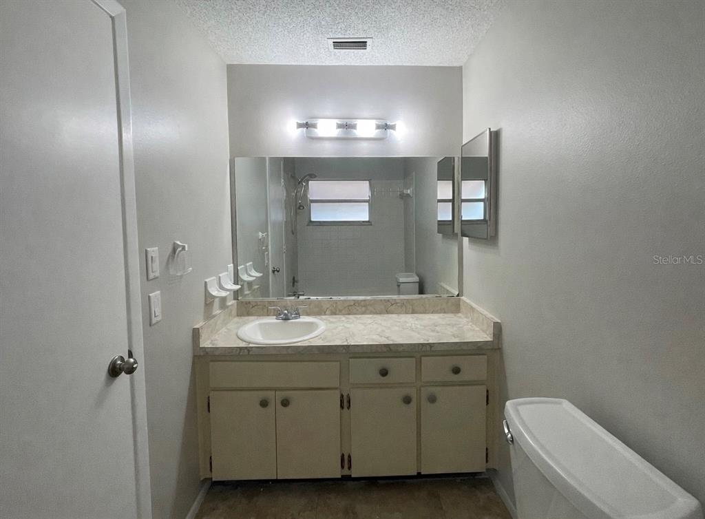 7986 Avenal Loop New Port Richey, FL 34655 - Photo 15 of 23 a bathroom with a sink a toilet and mirror
