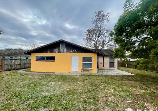 a front view of house with yard and trees in the background