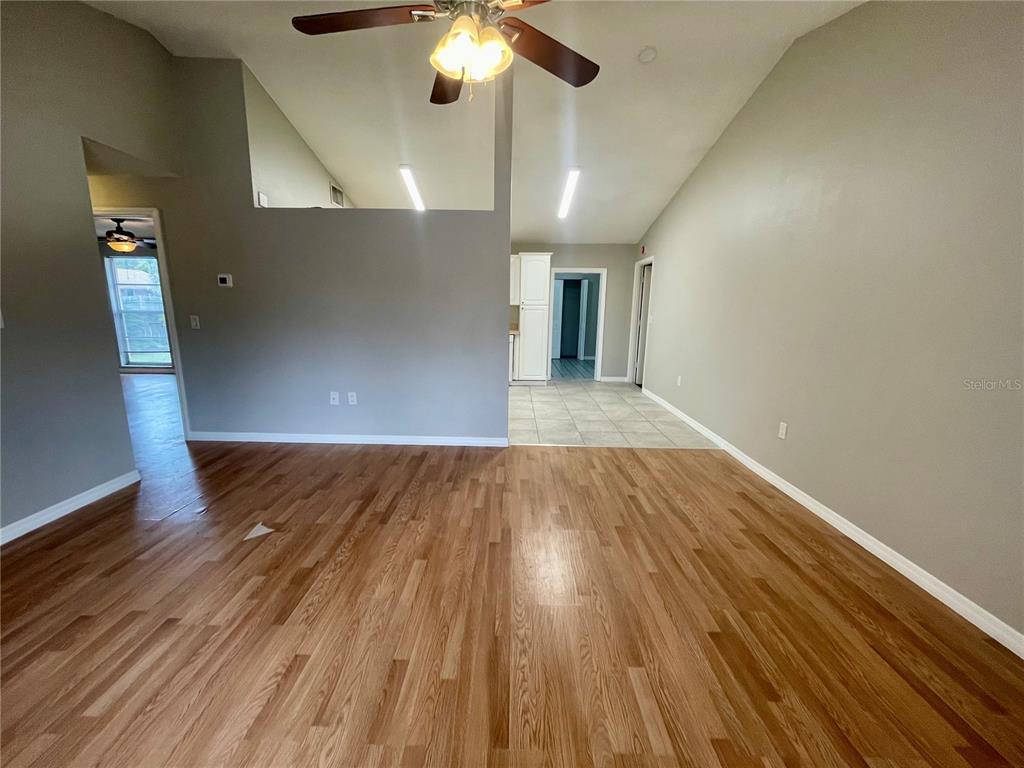 7986 Avenal Loop New Port Richey, FL 34655 - Photo 3 of 23 wooden floor in an empty room with a window