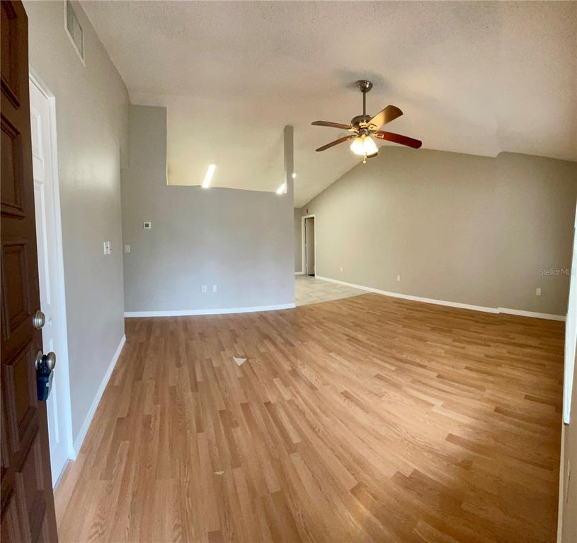 7986 Avenal Loop New Port Richey, FL 34655 - Photo 4 of 23 wooden floor in an empty room with a window