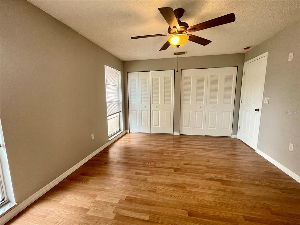 7986 Avenal Loop New Port Richey, FL 34655 - Photo 8 of 23 wooden floor in an empty room with a window