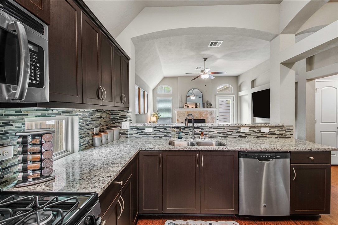 3014 Positano Loop Bryan, TX 77808 - Photo 13 of 23 a kitchen with kitchen island granite countertop wooden cabinets and a sink