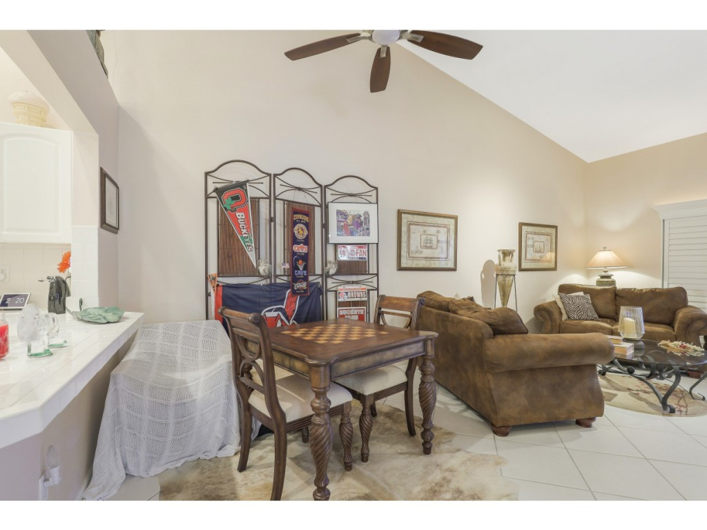 470 St Andrews Boulevard Naples, FL 34113 - Photo 13 of 32 a living room with furniture and a chandelier