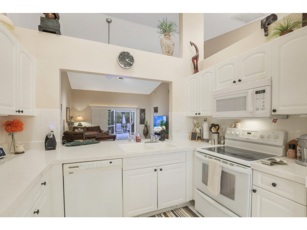 470 St Andrews Boulevard Naples, FL 34113 - Photo 16 of 32 a kitchen with cabinets appliances a sink and a counter top space