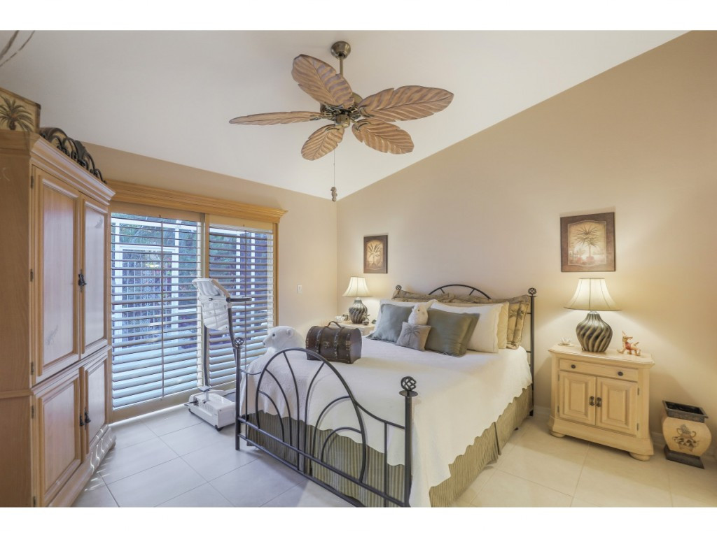 470 St Andrews Boulevard Naples, FL 34113 - Photo 19 of 32 a bedroom with a bed and a chandelier