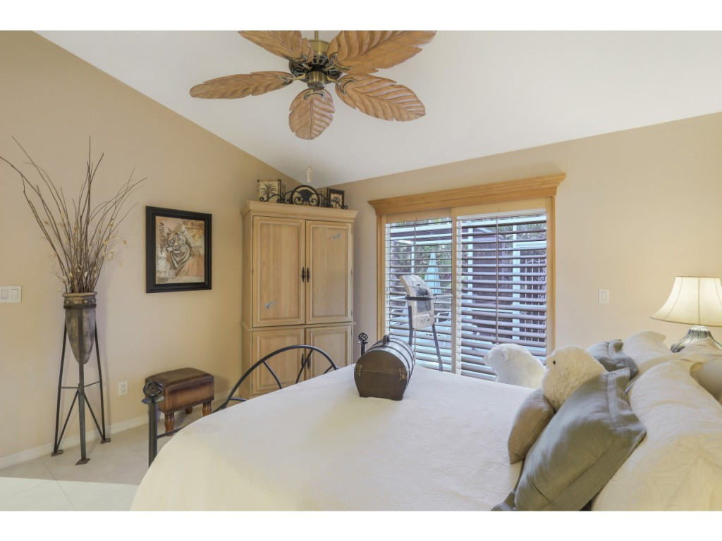 470 St Andrews Boulevard Naples, FL 34113 - Photo 20 of 32 a bedroom with a bed and a large window
