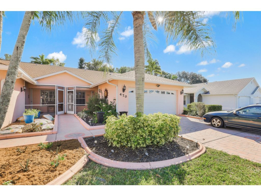 470 St Andrews Boulevard Naples, FL 34113 - Photo 26 of 32 a view of a patio with a table and chairs under an umbrella