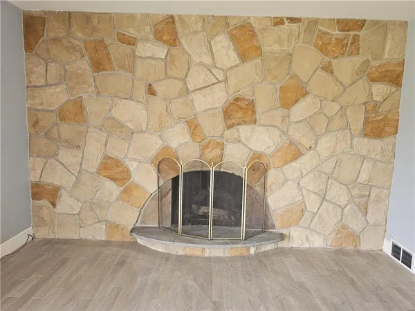 a kitchen with stainless steel appliances a stove a sink a refrigerator white cabinets and wooden floor