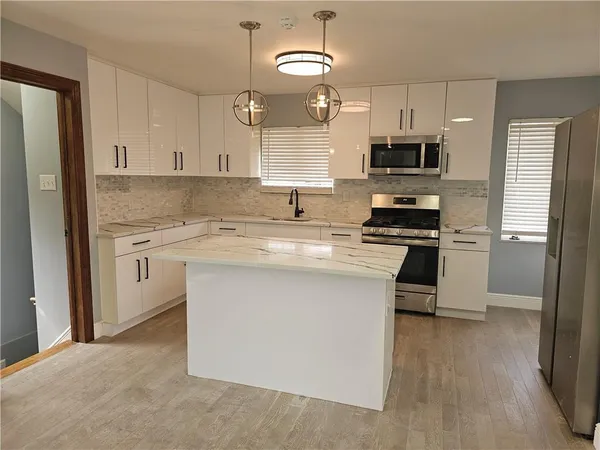 a kitchen with stainless steel appliances granite countertop a sink stove and cabinets