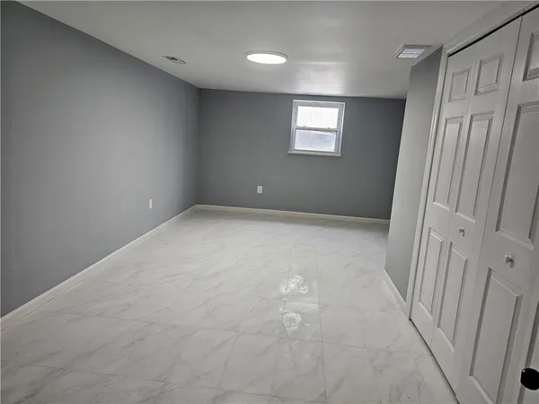 a view of a hallway with stainless steel appliances a refrigerator and chandelier