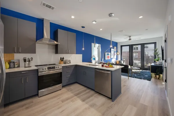 a large kitchen with stainless steel appliances wooden floors and wooden cabinets