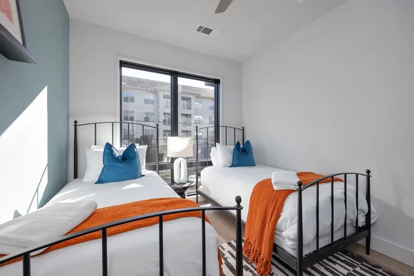 a bedroom with two beds and large window