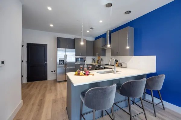 a kitchen with a dining table chairs and refrigerator