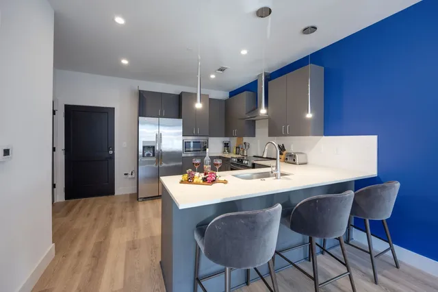 a kitchen with a dining table chairs and refrigerator