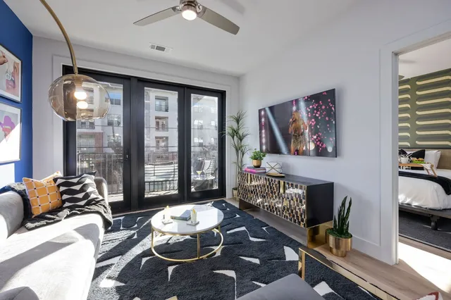 a living room with furniture and a floor to ceiling window