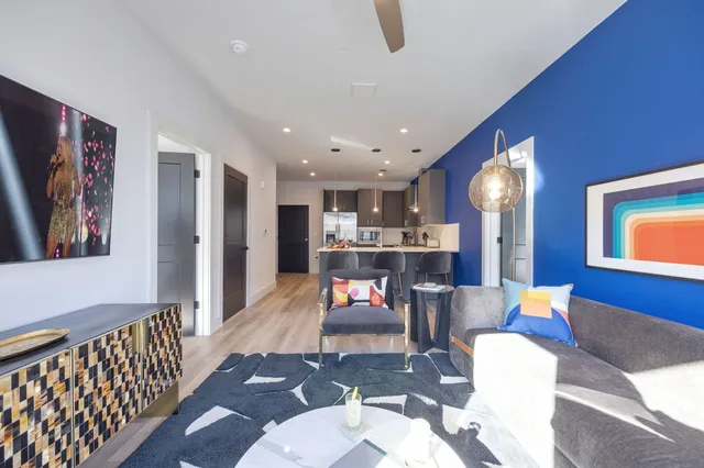 a living room with furniture and kitchen view