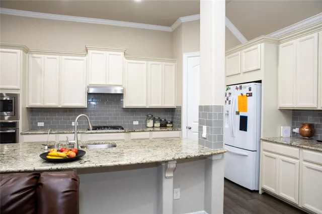 a kitchen with kitchen island granite countertop a sink and a stove