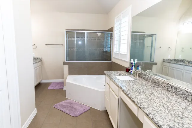 a white bath tub sitting in a bathroom next to a window