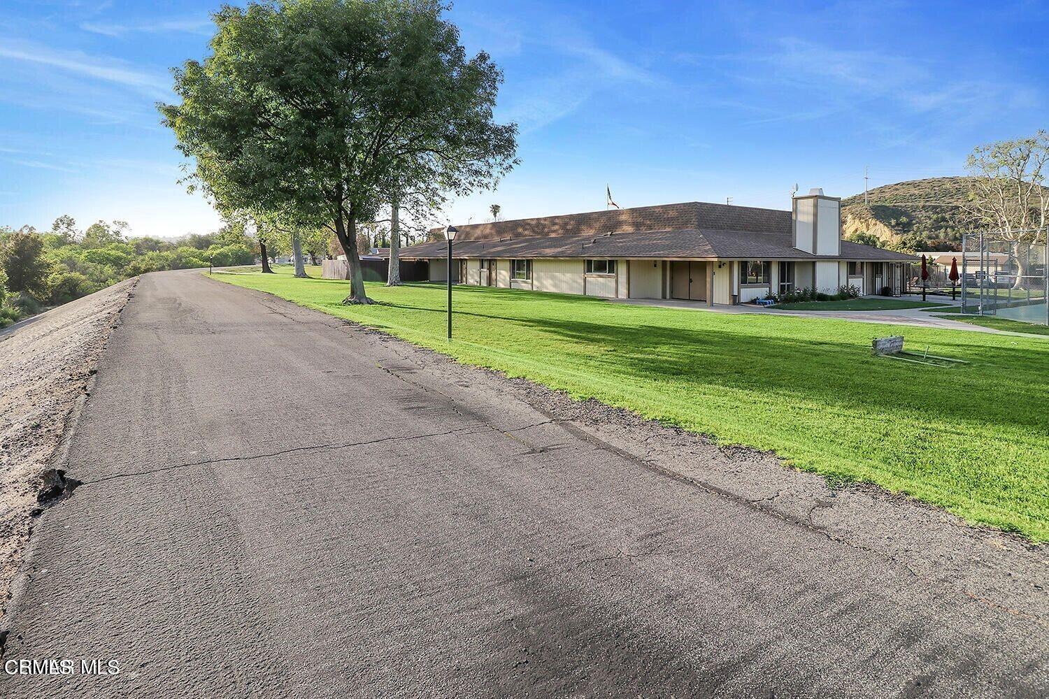 15750 Arroyo Drive, Unit 80 Moorpark, CA 93021 - Photo 18 of 19 a view of a big house with a big yard and palm trees