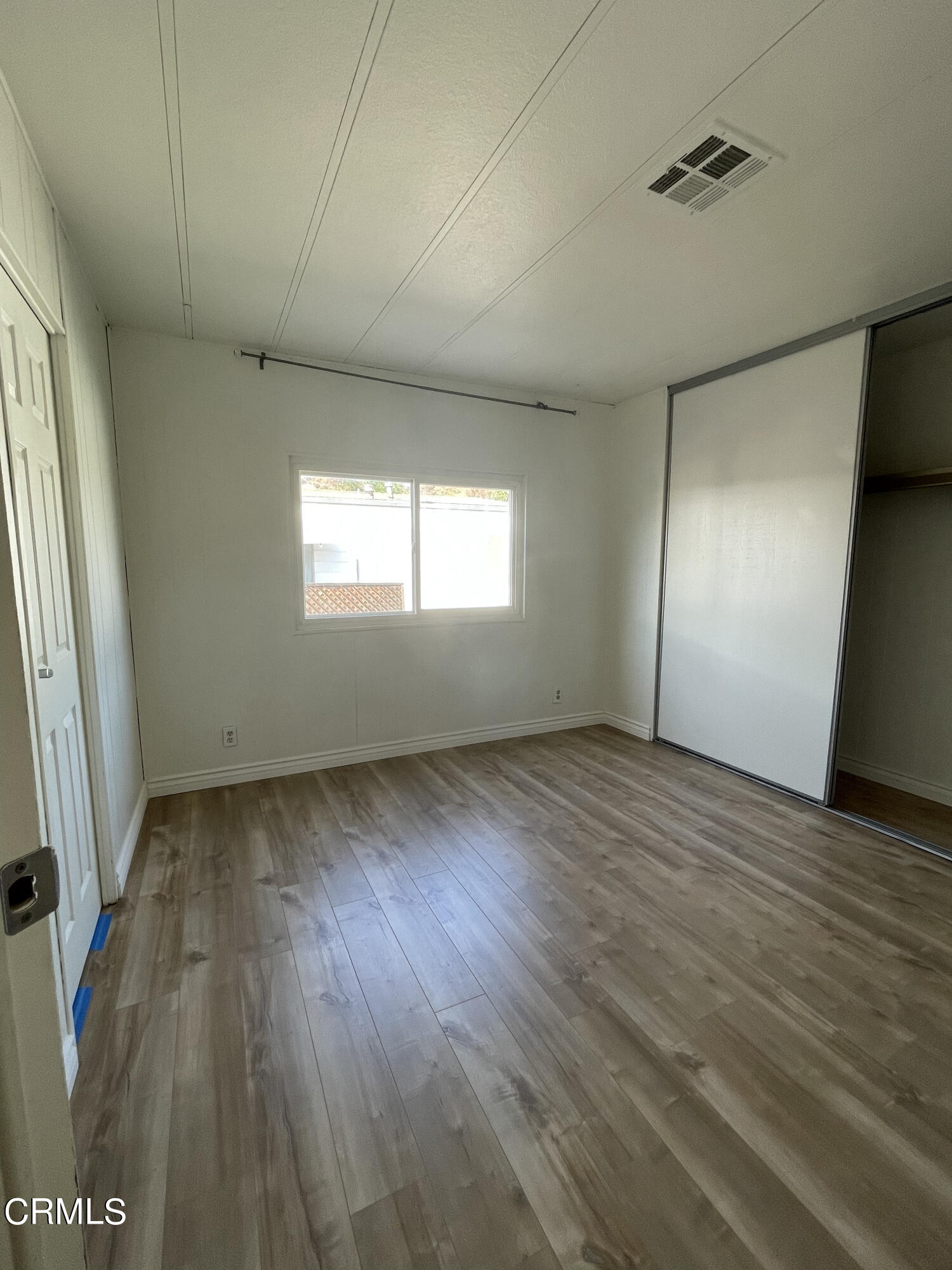 15750 Arroyo Drive, Unit 80 Moorpark, CA 93021 - Photo 8 of 19 an empty room with wooden floor and windows