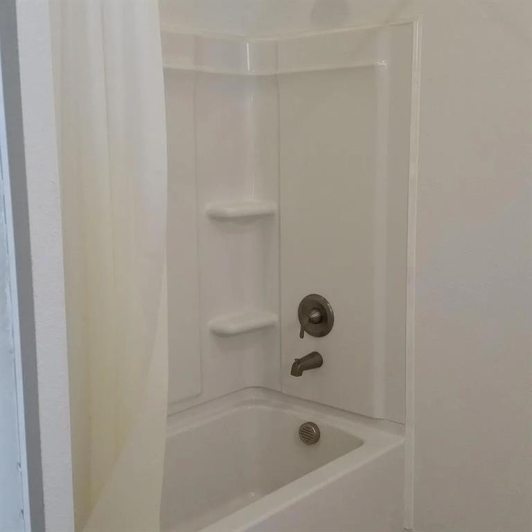 304 Fulton Street, Unit B Denton, TX 76201 - Photo 8 of 10 a bathroom with a bathtub
