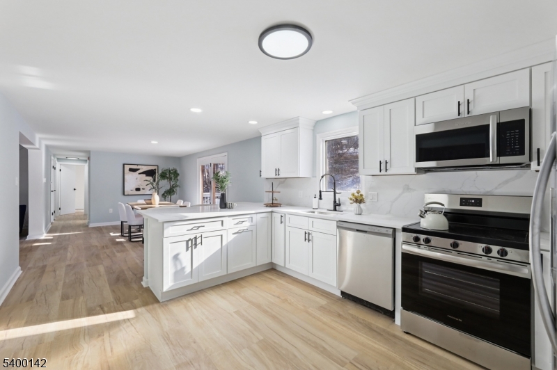 6 Maple Drive Vernon, NJ 07461 - Photo 11 of 47 a kitchen with stainless steel appliances granite countertop a stove top oven a sink dishwasher and a microwave oven with wooden floor