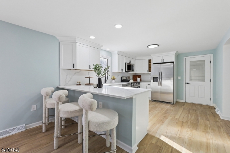 6 Maple Drive Vernon, NJ 07461 - Photo 12 of 47 a kitchen with white cabinets and chairs