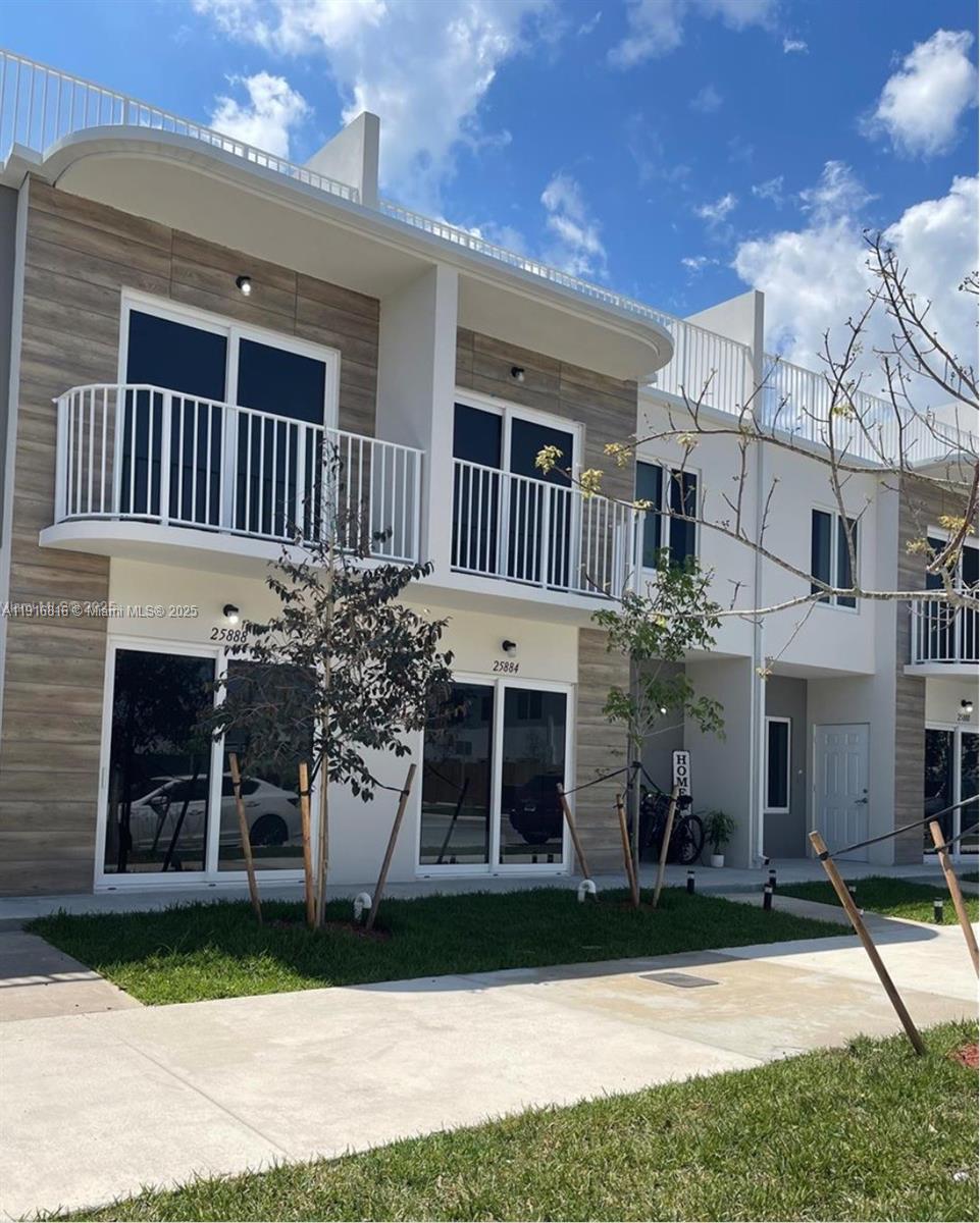 25842 Southwest 144th Avenue, Unit 25842 Homestead, FL 33032 - Photo 1 of 16 a front view of a house with garden