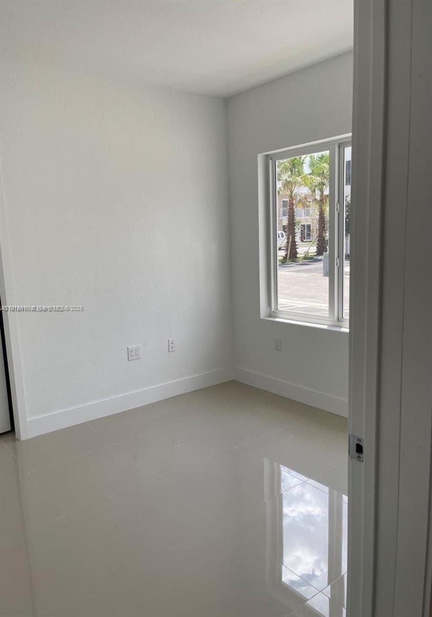 25842 Southwest 144th Avenue, Unit 25842 Homestead, FL 33032 - Photo 11 of 16 a view of an empty room with a window