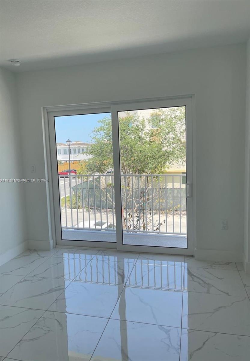 25842 Southwest 144th Avenue, Unit 25842 Homestead, FL 33032 - Photo 13 of 16 a view of an empty room with a window