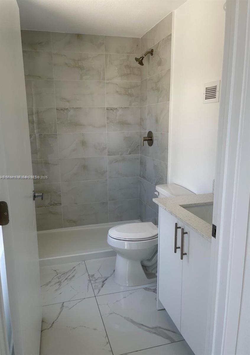 25842 Southwest 144th Avenue, Unit 25842 Homestead, FL 33032 - Photo 8 of 16 a bathroom with a toilet and shower