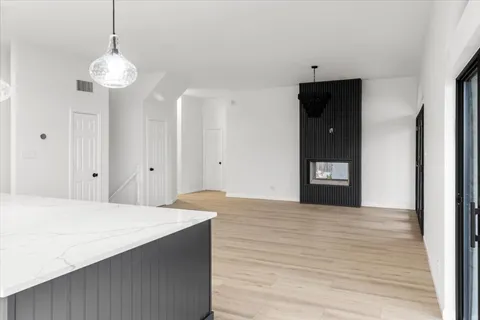 a view of an empty room with window and wooden floor