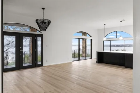 a view of a room with a large window and wooden floor
