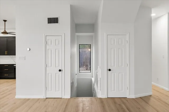 a view of an empty room with wooden floor and a window