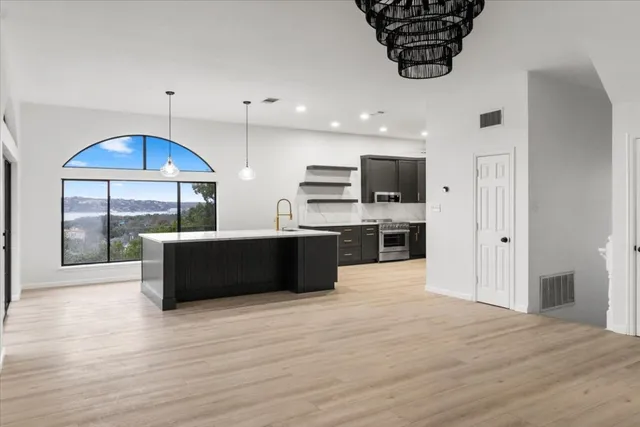a view of an empty room with window and wooden floor