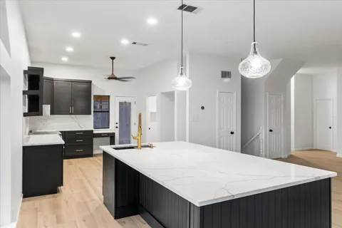 a large kitchen with kitchen island a sink stainless steel appliances and cabinets